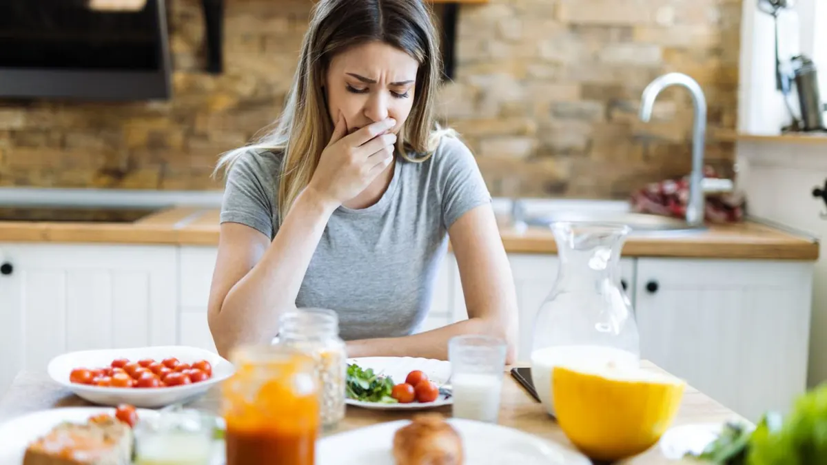 Mulher com náusea – possível efeito colateral gastrointestinal