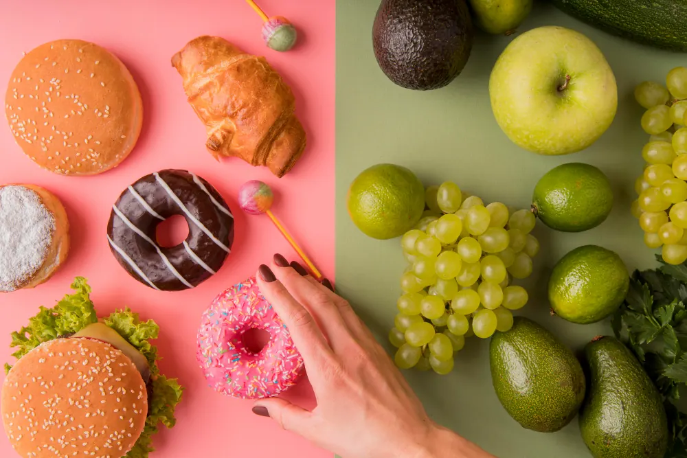 de um lado da imagem, doces e alimentos gordurosos, do outro frutas
