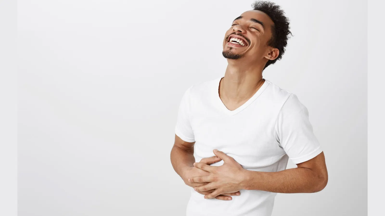 Homem sorrindo com a mão na barriga aliviado