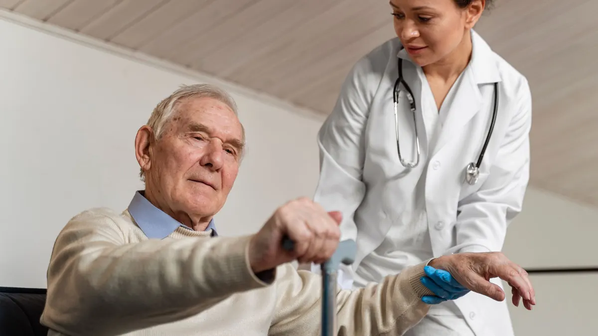 Médica ajudando paciente idoso a se levantar