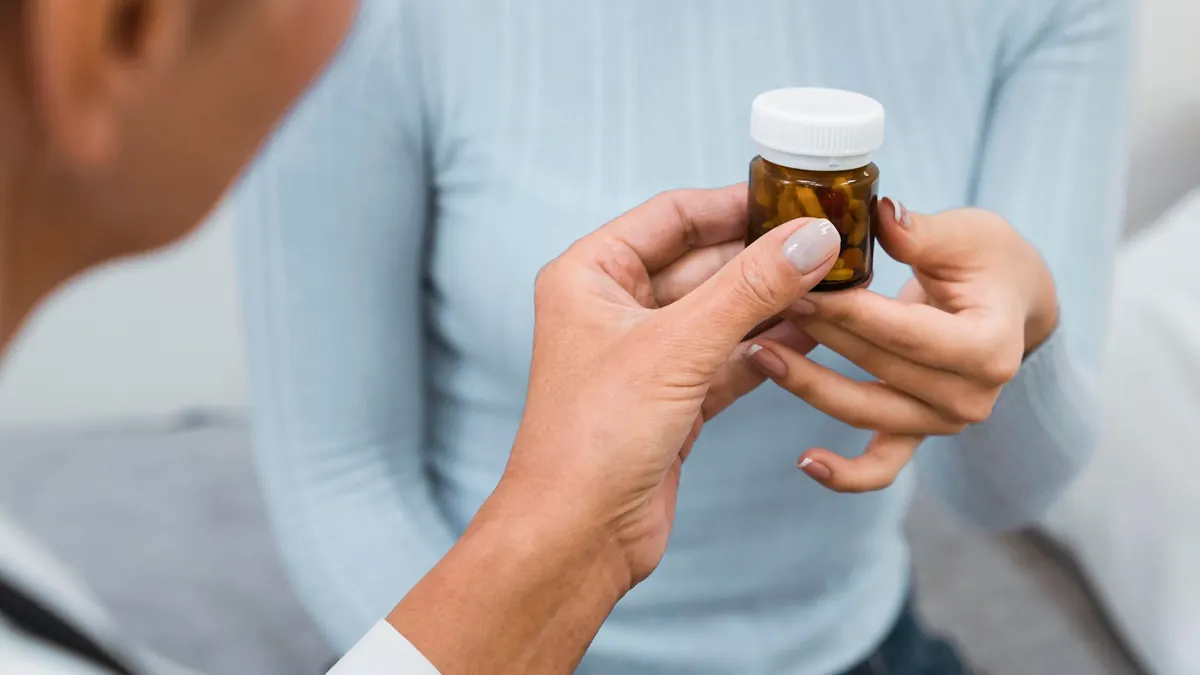 médico entregando pílulas a um paciente