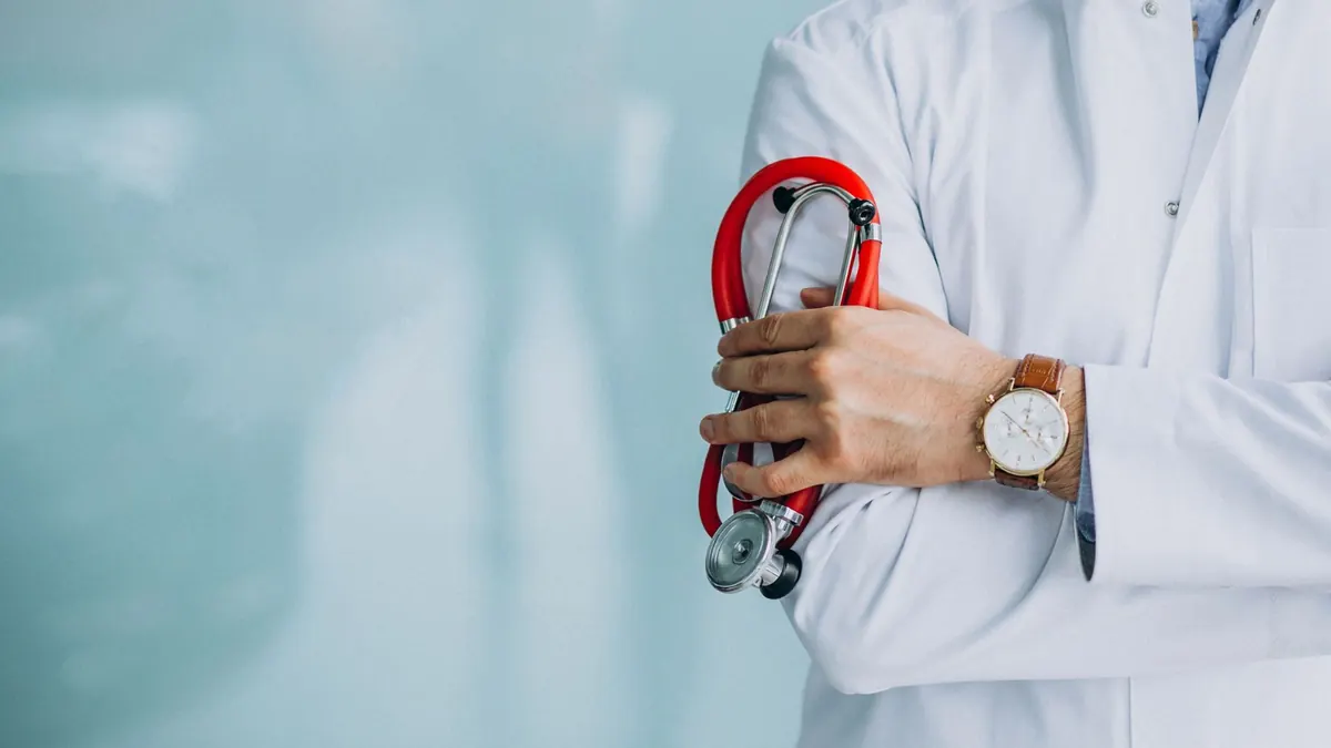 Médico jovem com estetoscópio usando jaleco